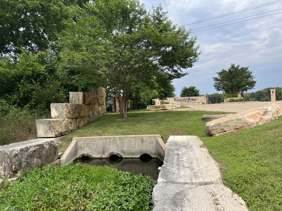 Subdivision entrance with stone wall and drainage
